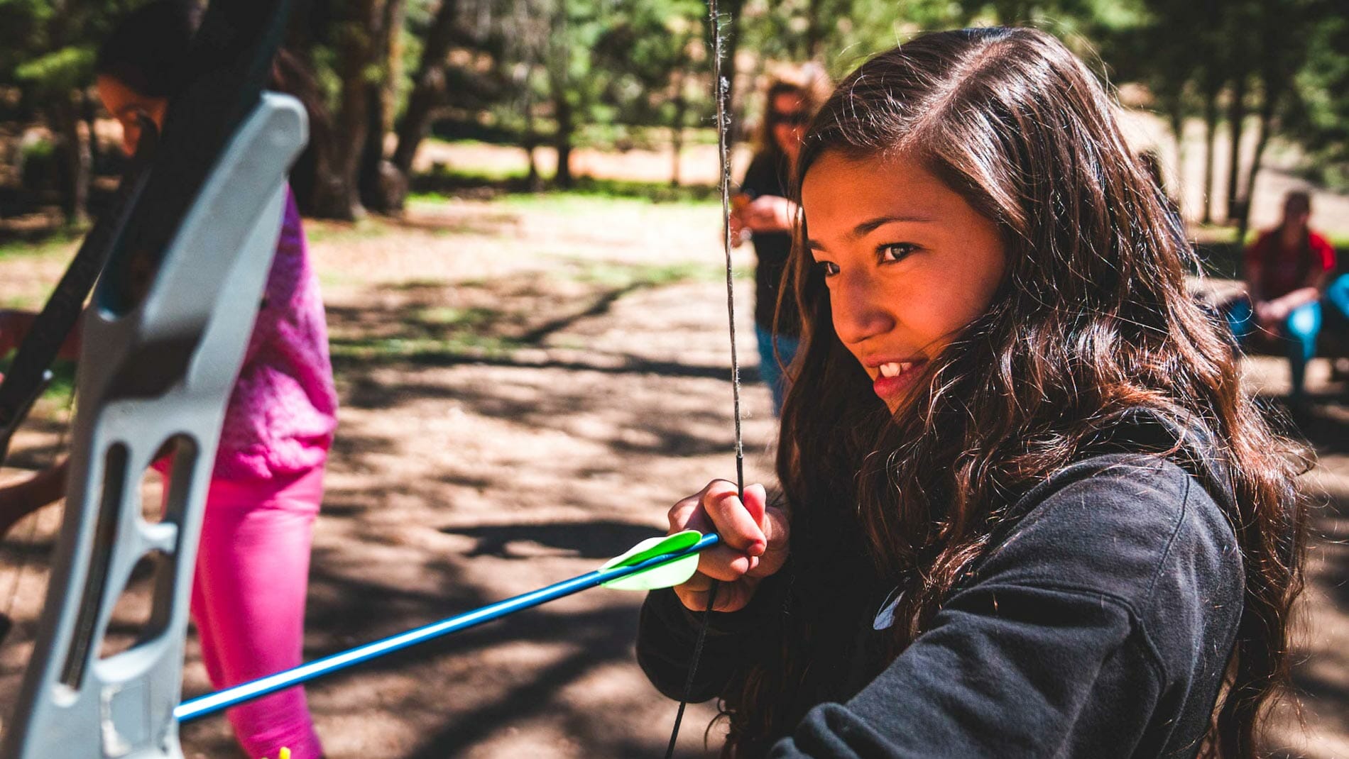 Girl drawing bow during Pali archery lesson