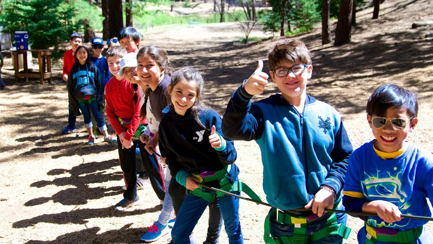 Students line up along rope while one gives thumbs up